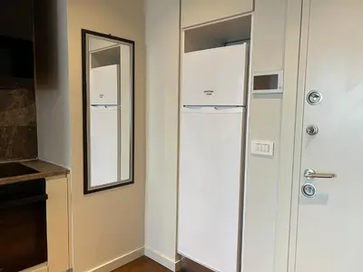 a white refrigerator in a room with a mirror at huzurlu ve şirin in Istanbul