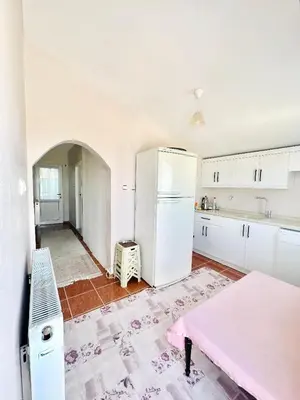 a kitchen with a white refrigerator and a pink table at Close to IST Airport, Sea view& peaceful apartment in Arnavutköy