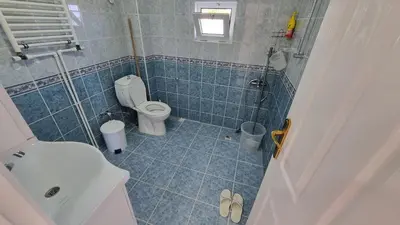 a blue tiled bathroom with a toilet and a shower at Close to IST Airport, Sea view& peaceful apartment in Arnavutköy