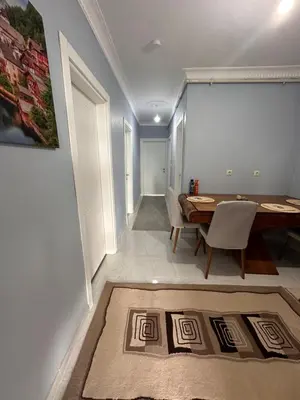 a dining room with a table and a rug at ALTAY Airport SUİT in Tayakadın