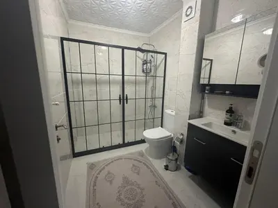 a bathroom with a shower and a toilet and a sink at ALTAY Airport SUİT in Tayakadın