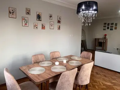 a dining room table with chairs and a chandelier at Spacious flat with wide view in Istanbul