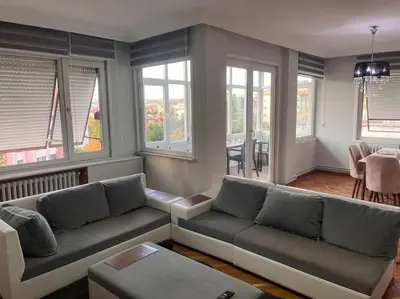 a living room with couches and a table and windows at Spacious flat with wide view in Istanbul