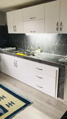 a kitchen with white cabinets and a sink at Farm Village in Sakarya