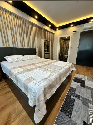 a bedroom with a large bed with a checked blanket at The Port Palace Hotel in Istanbul