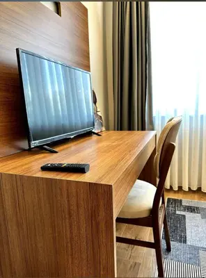 a desk with a computer monitor and a remote control at The Port Palace Hotel in Istanbul