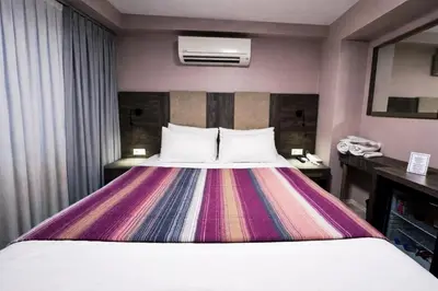 a hotel room with a bed with a colorful blanket at Yalı Bahçe Mudanya in Burgaz