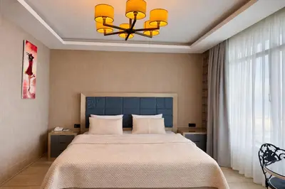 a bedroom with a large bed and a chandelier at Yalı Bahçe Mudanya in Burgaz
