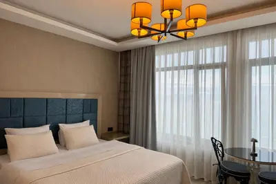 a bedroom with a bed and a table and a chandelier at Yalı Bahçe Mudanya in Burgaz