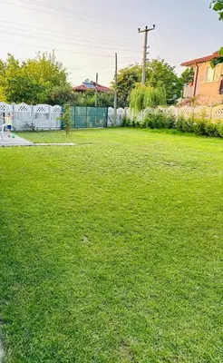 a field of green grass with a fence at Farm Village in Sakarya