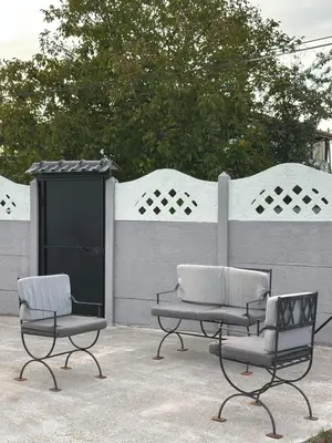two chairs and a table in front of a fence at Farm Village in Sakarya