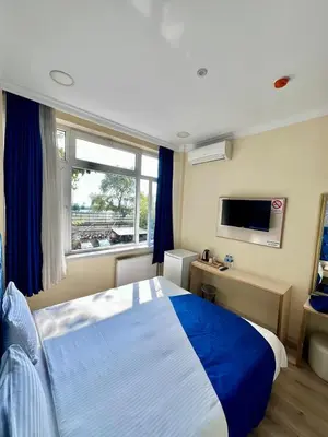 a bedroom with a large bed and a window at Grand Ararat Hotel in Istanbul
