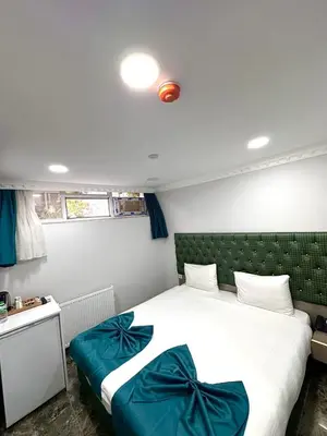 a bedroom with a large bed with blue pillows at Grand Ararat Hotel in Istanbul