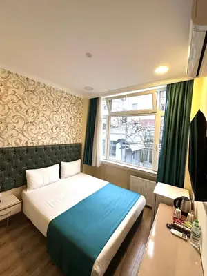 a bedroom with a large bed and a window at Grand Ararat Hotel in Istanbul