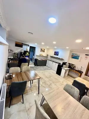 a living room with tables and chairs and a kitchen at Grand Ararat Hotel in Istanbul