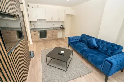 a living room with a blue couch and a table at Guest Suites in Istanbul
