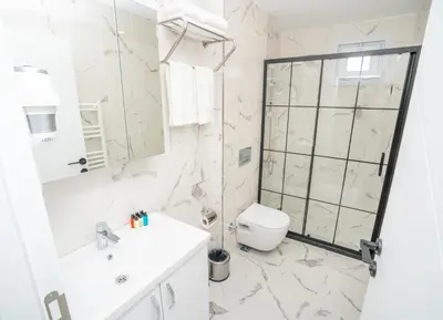 a white bathroom with a shower and a toilet at Guest Suites in Istanbul