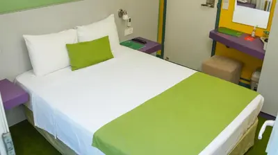 a bedroom with a large white bed with a green pillow at Mini Harem Hotel in Istanbul