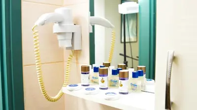 a bathroom with a phone and a shelf with cosmetics at Mini Harem Hotel in Istanbul