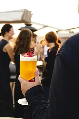 a person holding a glass of beer with a garnishment at The St. Regis Istanbul in Istanbul