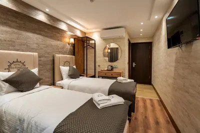 a hotel room with two beds and a mirror at Old Harbour Hotel istanbul in Istanbul