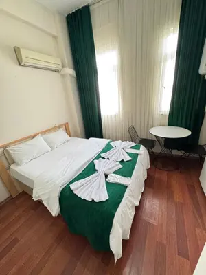 a bedroom with a bed with a green and white blanket at Taksim Plaza Suite in Istanbul