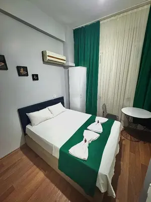 a bedroom with a bed with a green and white blanket at Taksim Plaza Suite in Istanbul