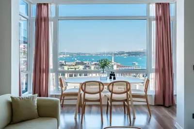 a dining room with a table and chairs and a large window at Stay Beyond the Bosphorus #5 in Istanbul