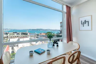 a dining room with a table and a large window at Stay Beyond the Bosphorus #5 in Istanbul