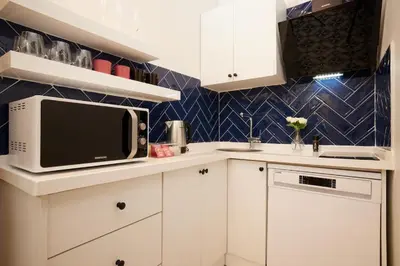 a kitchen with white cabinets and a microwave at Historic High-Ceiling 2-Flat Combo - Taksim in Istanbul