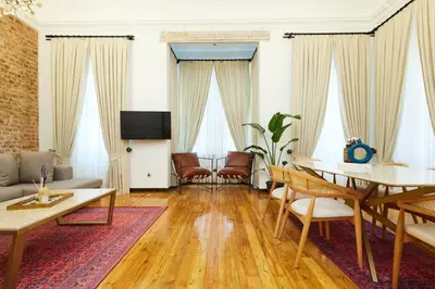 a living room with a table and chairs at Historic High-Ceiling 2-Flat Combo - Taksim in Istanbul