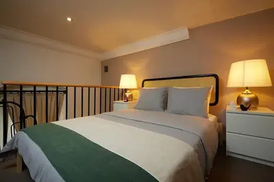 a bedroom with a large white bed with two lamps at Historic High-Ceiling 2-Flat Combo - Taksim in Istanbul