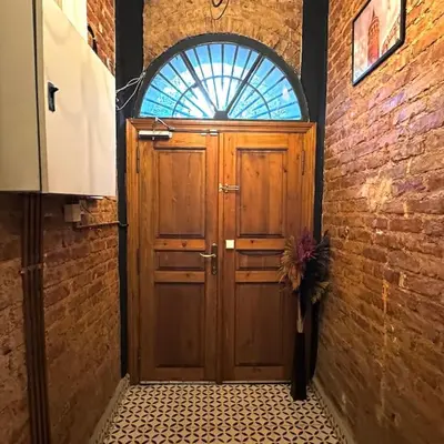 a wooden door with a window in a brick wall at Beyoğlu'nda dubleks tarihi daire in Istanbul