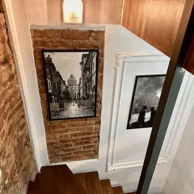 a room with two pictures on a brick wall at Beyoğlu'nda dubleks tarihi daire in Istanbul