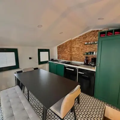 a kitchen with a black table and green cabinets at Beyoğlu'nda dubleks tarihi daire in Istanbul