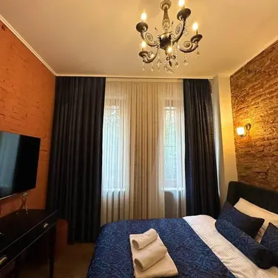 a bedroom with a blue bed and a chandelier at Beyoğlu'nda dubleks tarihi daire in Istanbul