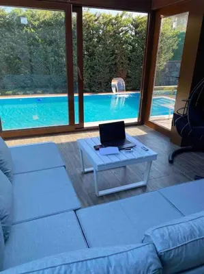 a living room with a couch and a laptop on a table at Tuzlada Ferah Alani Havuz,Bahçe ve tüm rahatlıklar kişiye özel alan in Tuzla