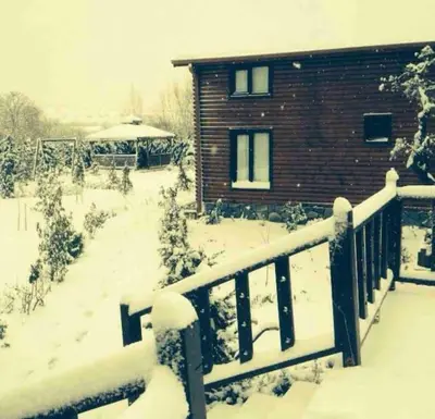 a house covered in snow next to a fence at Tuzlada Ferah Alani Havuz,Bahçe ve tüm rahatlıklar kişiye özel alan in Tuzla
