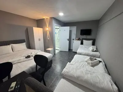 a hotel room with two beds and a desk and a chair at Old City Kadıköy Otel in Istanbul
