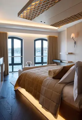 a bedroom with a large bed with windows at Vakko Hotel Sumahan Bosphorus in Istanbul