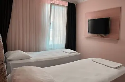 a hotel room with two beds and a flat screen tv at Ottoman Hotel Sakarya in Sakarya