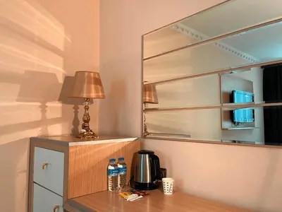 a mirror and a table with a coffee maker and a lamp at Ottoman Hotel Sakarya in Sakarya