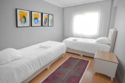 a bedroom with two beds and a table and a window at New furniture, zero air conditioning, modern and quiet 19 in Istanbul