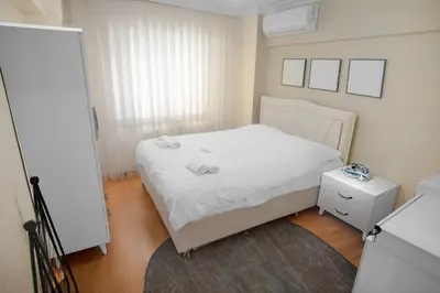 a small bedroom with a white bed and a rug at New furniture, zero air conditioning, modern and quiet 19 in Istanbul