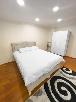 a bedroom with a large white bed and a rug at Ground floor apartment in a quiet area 17 in Istanbul