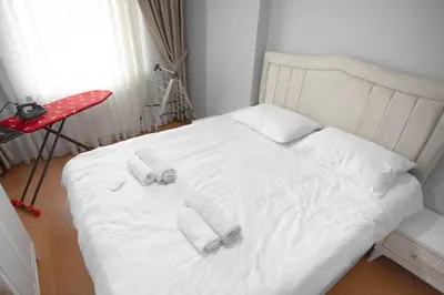 a white bed with four pillows on it in a room at Large central apartment in a quiet area 40 in Istanbul