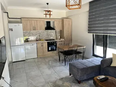 a kitchen with a refrigerator and a table in a room at Yalova Cozy Home in Yalova