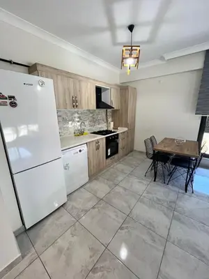 a kitchen with a white refrigerator and a table at Yalova Cozy Home in Yalova