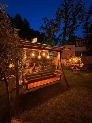 a park bench with lights on it at night at Kerpe Bungalov Hotel in Kandıra