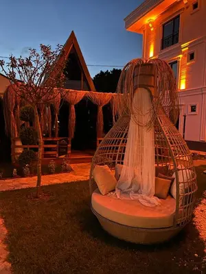 a bird cage sitting in the yard of a house at Kerpe Bungalov Hotel in Kandıra